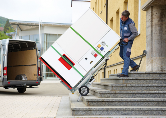 Op de foto wordt de CargoMaster hefkrik gebruikt om een verkoopautomaat de trap op en af te transporteren.