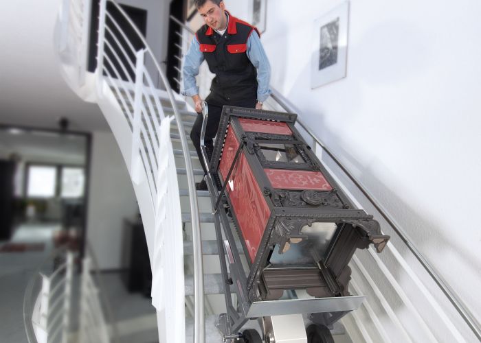The picture shows the CargoMaster A350 stair climber being used to transport an oven up and down stairs.